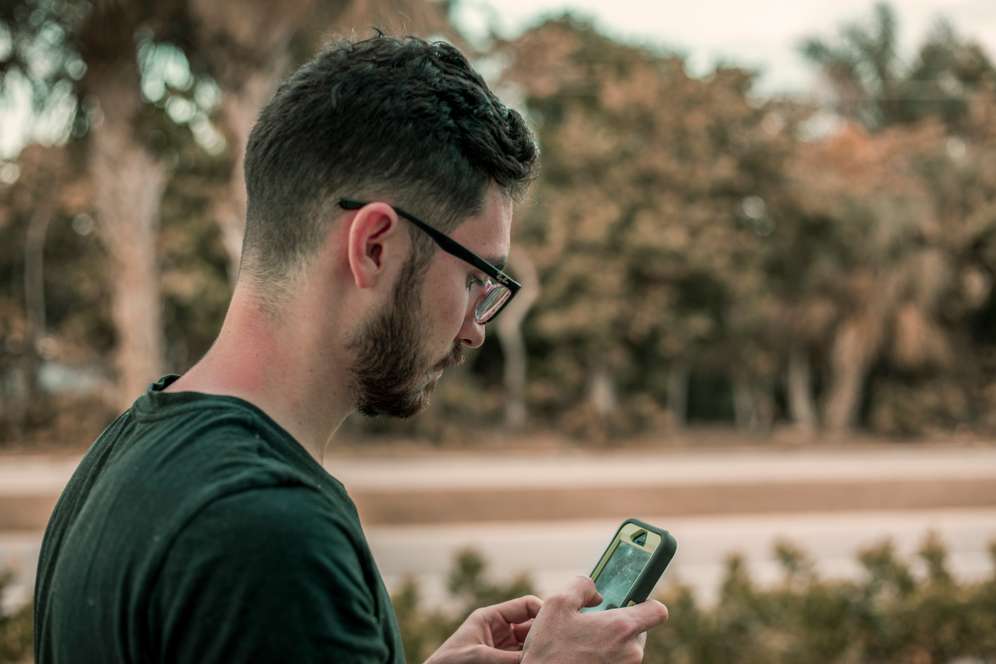 Man checks phone roadside after crash—St. Petersburg personal-injury help: auto accidents, motorcycle, auto/pedestrian, auto/bicycle, slip & fall, product liability.